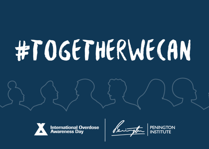 Dark blue background with "#Togetherwecan" in white text. Under the text is a faint white line outlining heads and shoulders starting on the left and creating the silhouettes to the right side. A total of 8 different silhouettes. Under those it has a logo and white text "International Overdose Awareness Day." then there is a straight white line. On the other side of the white line is a white signature and a smaller vertical white line. On the right of that line is white text "Pennington Institute"